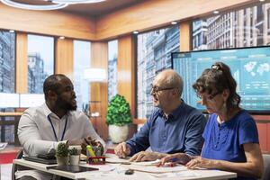 Senior citizens discussing retirement savings with a financial advisor in a modern office. Consulting a planner about comprehensive retirement plans, including pension options. photo