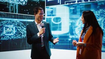 Presenter and specialist guest talking at AI summit bringing together tech startups professionals, exploring latest developments in artificial intelligence and deep learning technology, camera B photo
