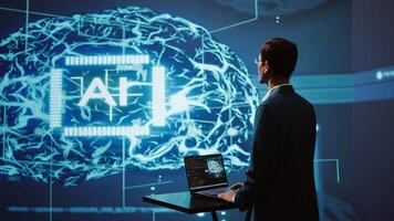 AI system administrator using laptop device in high tech futuristic workspace. Man working on notebook to automatize tasks using artificial intelligence technology, camera B photo