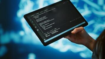Software developer with tablet programming artificial intelligence computing simulating human brain. Close up of IT professional using device, building AI machine learning algorithms, camera A photo
