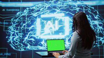 IT specialist using green screen laptop and AI technology for business data analysis in high tech setting. Engineer works on mockup notebook to automatize tasks using artificial intelligence, camera B photo