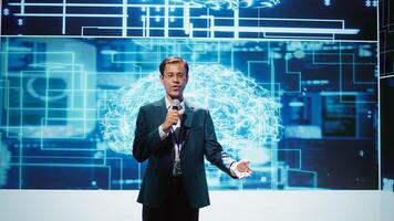Upbeat presenter inviting engineer on stage during global IT conference to talk about subjects such as enterprise AI, deep learning, big data, neural networks and cognitive computing, camera B photo