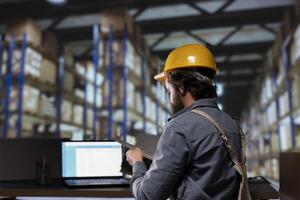 Production supervisor dealing with inventory management in depot, reading list of stock invoices and orders for distribution. Engineer in warehouse planning new merchandise shipment. photo