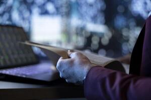 Businessman reading monthly accounting documents to ensure international development, following stock market trend at night. Shareholder working with legal papers, creating investment plan. Close up. photo