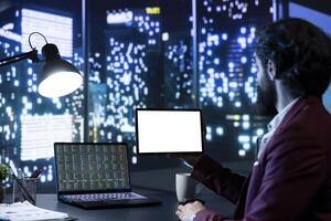 Legal expert looking at isolated display on modern tablet, checking global investments online and working after hours. Chairman holding device running white screen, blank mockup layout. photo