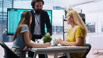 Financial advisor showing data graphs on big screen to customers, analyzing market trends to do forecasting. Mom and gen Z girl checking investment plan on display made by agent, camera A video