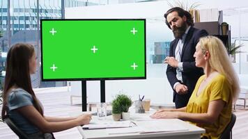 Broker in office offering financial advice to clients, looking at forex index values on green screen display. Financial advisor analyzing customers market shares on chroma key device, camera A video