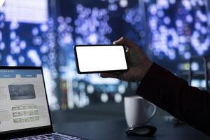 Expert accountant uses blank copyspace display on phone, trying to develop company activity on global market. Entrepreneur examines white mockup screen in skyscraper office building. photo