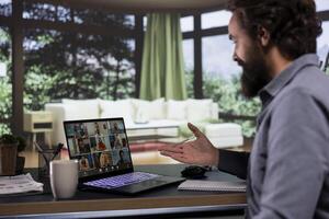 From his opulent mountain cabin, executive board member communicates with investors via teleconference network, joining for innovative brief debate. Entrepreneur sets international success plans. photo
