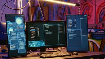 High tech computer systems running malicious code in messy empty criminals hideaway. Virus script running on PC monitors in empty neon lit warehouse used by hackers to commit illegal activities photo