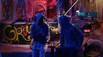 Trucking right shot of hackers brainstorming ways to find exploits for system vulnerabilities and use them to sell the fix to system owner. Malicious programmers using laptop to do hacking photo