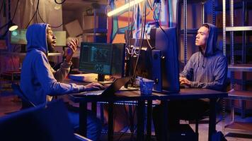 Hackers brainstorming ways to go undetectable by antivirus software installed on systems and successfully trick firewalls, discussing methods of developing zero day exploit in secret bunker photo
