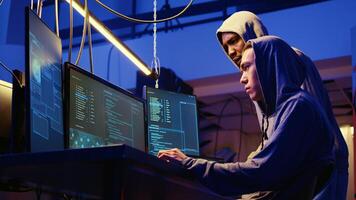 Hackers brainstorming ways of getting past anti tamper measures implemented by companies trying to protect their products. Crackers trying to pirate software and game releases photo