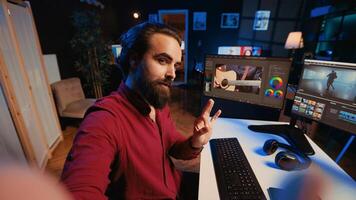 Videographer using selfie camera to record tutorial on how to use software to create visual effects for projects. Expert teaching online viewers to use post production techniques, POV shot photo