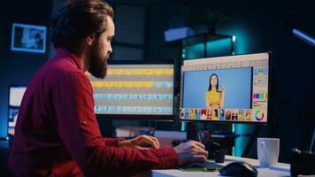 Photographer using photo editing software on PC display in multimedia creative studio, making adjustment on graphic tablet. Freelancer using retouching program on touchscreen device, panning shot