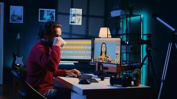 Photographer feeling tired from using photo editing software on PC display, drinking cup of coffee. Freelancer enjoying hot beverage while using photographs retouching program
