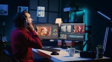 Videographer uses software to create visual effects for projects while relaxing with some music. Professional wearing headphones using post production techniques to edit raw footage photo