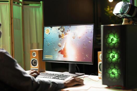 Gamer in neon lit apartment home shooting meteorites in spaceship flying singleplayer game on computer desktop. Player navigating galaxy, exploding enemies in simulation game on gaming PC photo