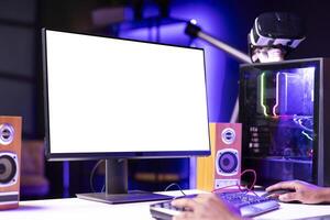 Gamer using keyboard and mouse to play videogame on gaming PC isolated screen monitor. Man in apartment at night using high tech computer peripherals to defeat foes on mockup display photo