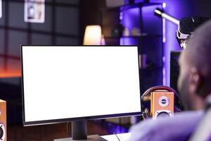 Player looking at gaming PC isolated screen, playing singleplayer videogame in neon lit apartment. Man in RGB illuminated home using enjoying game on mockup computer monitor photo