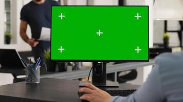 Worker at desk with greenscreen desktop, analyzing isolated computer layout with chromakey copyspace template. Woman sitting at workstation using blank display on pc to work on startup. photo