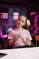 Gen Z entertainer utilizes high quality recording gear to shoot introductory segment for vlog. Young internet star in pink neon studio welcomes devoted fan community, introducing today subject photo