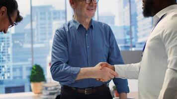 Senior people consulting financial advisor about retirement and pension planning, shaking hands for securing the future with life insurance and savings. Financial options in modern office. Camera A. photo