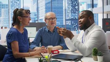 Elderly pair meeting with a financial expert to explore comprehensive retirement strategies, including savings, pension plans and investments. Looking into options to secure finances. Camera B. photo