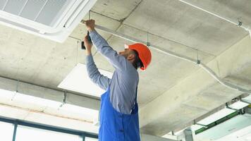 Technician worker installs air conditioning system and heat recovery system at office video
