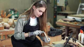 Attractive middle aged woman carpenter designer works with ruler, make notches on the tree in workshop. Image of modern femininity. Concept of professionally motivated women video