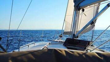 Yacht sailing in an open sea. Close-up view of the deck, mast and sails. Yachting concept. High quality 4k footage video