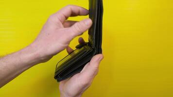 Empty black leather wallet. Man's hands open empty billfold, view from top video