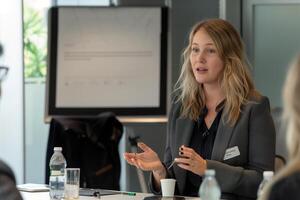 A confident female executive delivering a business presentation in a modern boardroom photo