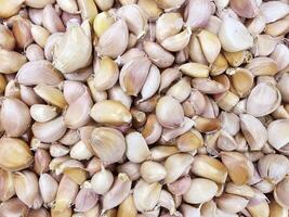 A pile of fresh garlic cloves. many garlic on shelf for sell in supermarket photo