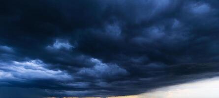 Bad or moody weather sky and environment. the dark sky with heavy clouds converging and a violent storm before the rain. carbon dioxide emissions, greenhouse effect, global warming, climate change. photo
