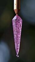 Twig with magenta jewelry droplet resembling liquid on titanium photo