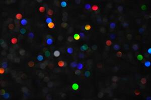 Abstract black background with bokeh of different colors. photo