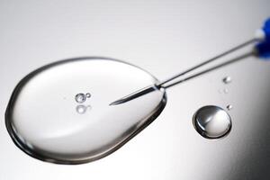 A drop of medicine flowing from a syringe with a needle. photo