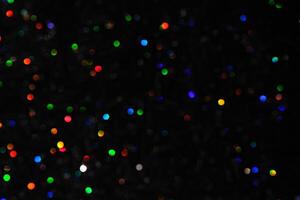 Abstract black background with bokeh of different colors. photo