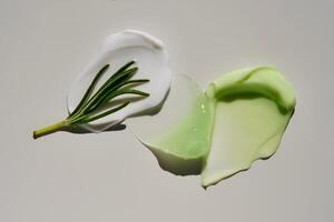 Texture of cosmetic creams with rosemary on a gray background. photo