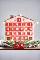 Christmas Advent calendar in the shape of a house with boxes making up the number 2025. photo