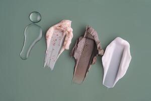 Textures of different cosmetic products on a green background. photo