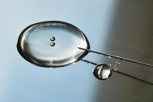 A drop of medicine flowing from a syringe with a needle. photo