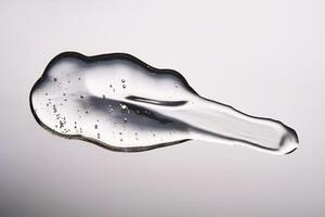 A smear of cosmetic gel close-up on a gray background. Appetizing texture with bubbles. photo