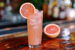 Enjoy the chic ambiance of a retro bar while savoring a pink grapefruit cocktail, a refreshing blend of ice, lime, and tropical flavors. Embrace the elegant setting and celebrate in style photo