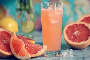 A tall glass of refreshing grapefruit juice with a slice of lime, surrounded by fresh grapefruit halves. The image offers a vibrant and nostalgic retro vintage feel photo