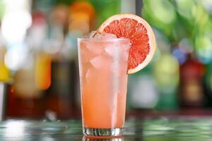 Enjoy the chic ambiance of a retro bar while savoring a pink grapefruit cocktail, a refreshing blend of ice, lime, and tropical flavors. Embrace the elegant setting and celebrate in style photo