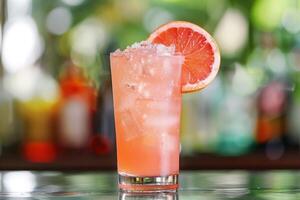 Enjoy the chic ambiance of a retro bar while savoring a pink grapefruit cocktail, a refreshing blend of ice, lime, and tropical flavors. Embrace the elegant setting and celebrate in style photo