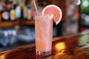 Enjoy the chic ambiance of a retro bar while savoring a pink grapefruit cocktail, a refreshing blend of ice, lime, and tropical flavors. Embrace the elegant setting and celebrate in style photo
