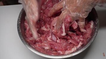 Young woman cooks raw marinated pork in a bowl and wrap it in clear plastic. video